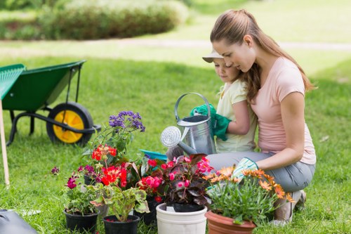 Gardener enhancing curb appeal through hedge trimming